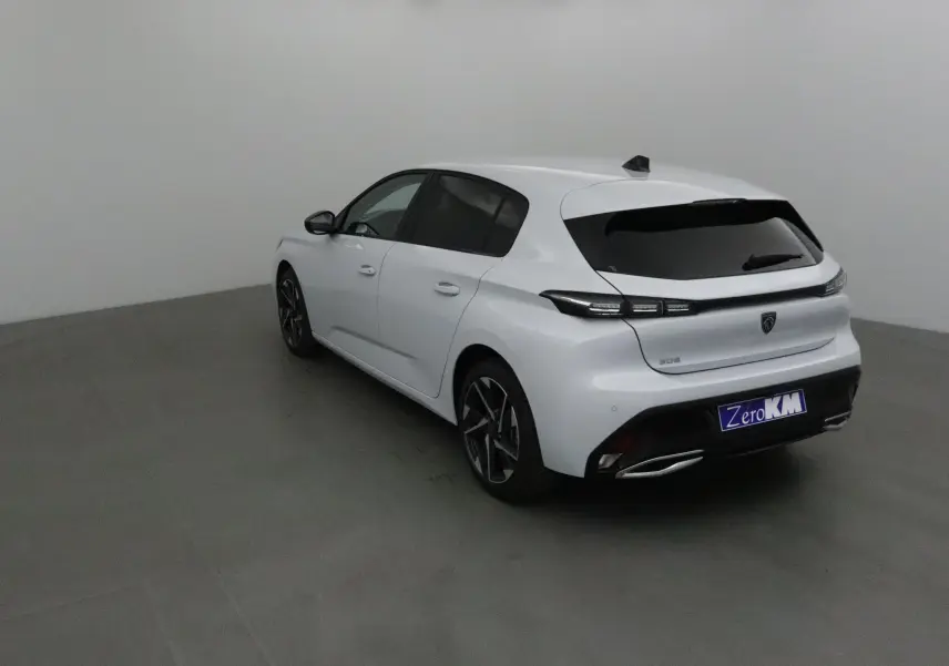 Peugeot 308 blanc Okenite vue 3/4 arrière droit avec vitres teintées et jantes alliage noires.