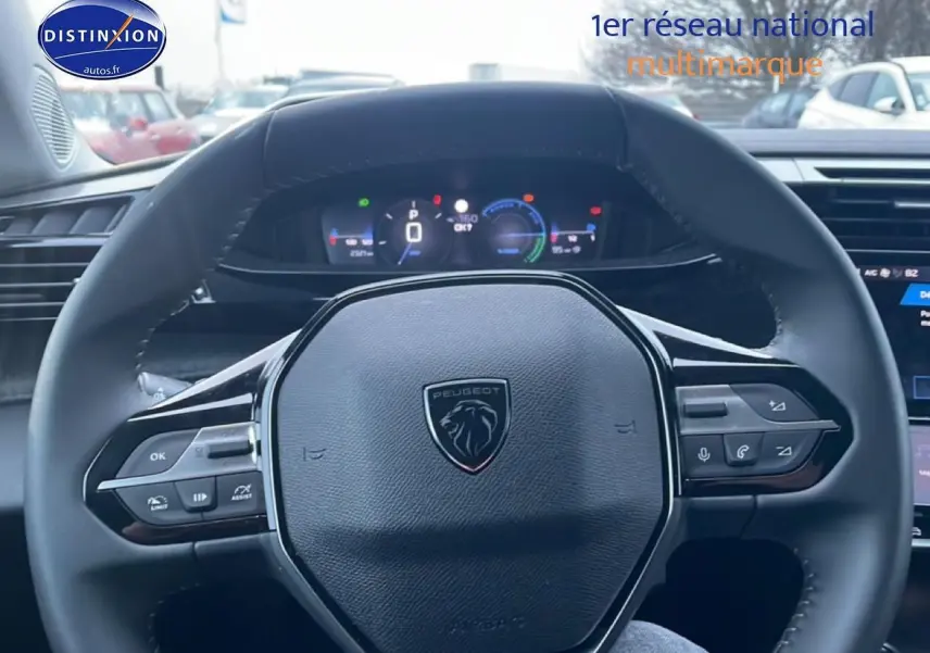 Vue rapprochée du volant multifonction noir de la Peugeot 308 1.2 hybrid 145 allure e-dcs6, tableau de bord numérique visible.