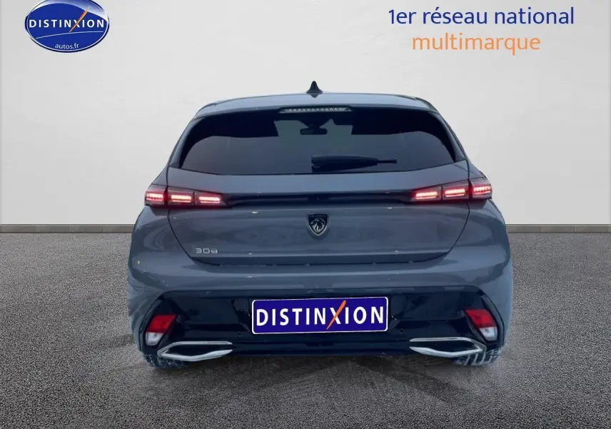 Vue arrière d'une Peugeot 308 gris sélénite 2025 avec feux arrière LED allumés et lunette arrière surteintée.