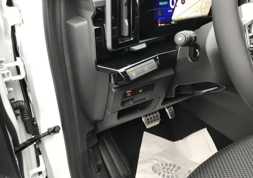 Vue intérieure côté conducteur du Renault Austral blanc, avec tableau de bord numérique et pédales sport en aluminium.