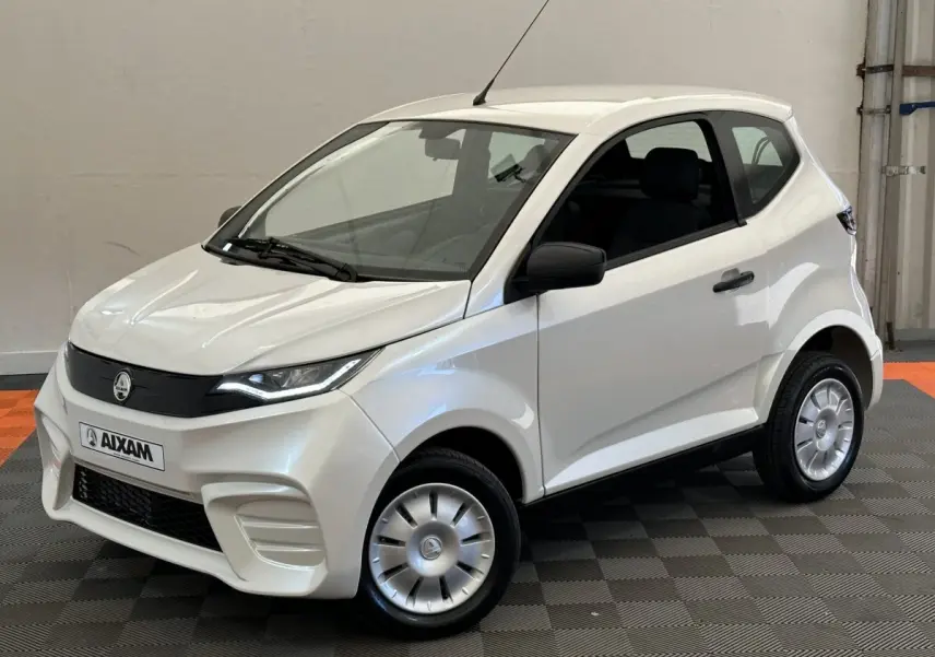 Vue 3/4 avant droit d'une Aixam Ambition E City Pack blanche 2026 avec rétroviseur caméra côté conducteur.
