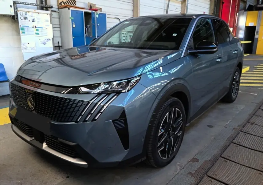 Peugeot 3008 bleu en 3/4 avant droit dans un garage, avec calandre noire et phares LED distinctifs.