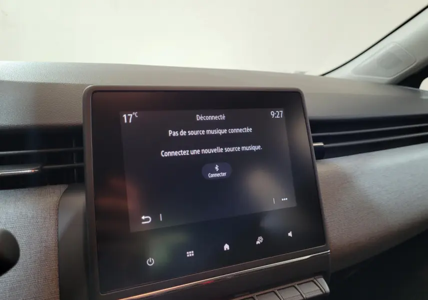 Écran tactile central de la Renault Clio gris foncé, vue rapprochée de l’intérieur côté passager.