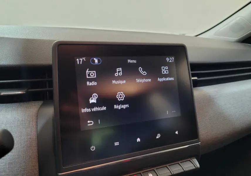 Écran tactile central de la Renault Clio gris foncé, vue rapprochée du tableau de bord côté passager.
