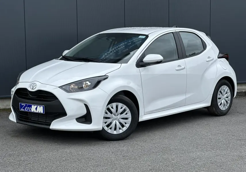 Toyota Yaris hybride blanc pur vue 3/4 avant droit avec calandre noire et jantes tôles.