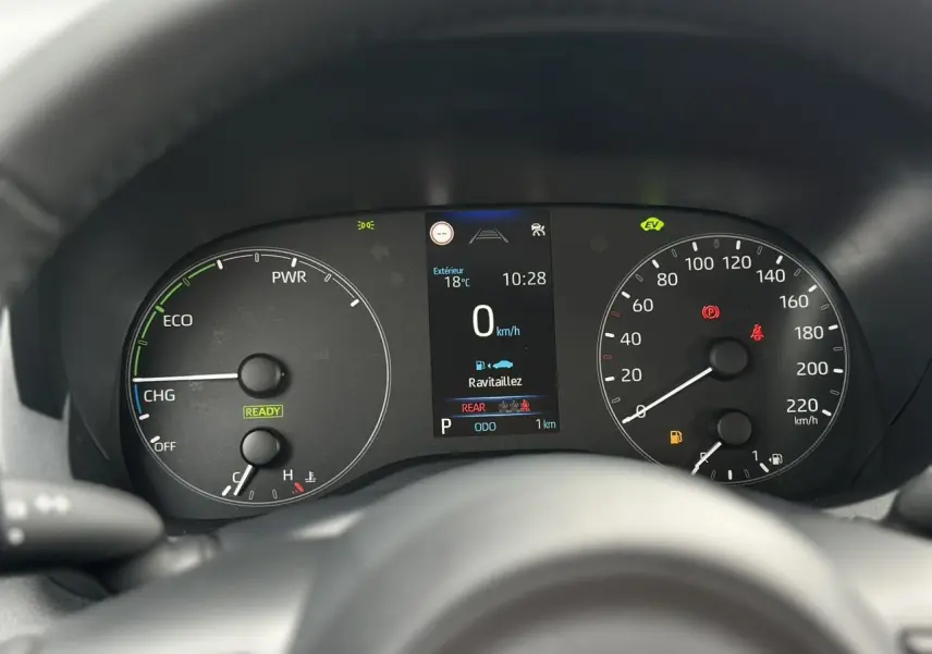Vue rapprochée du tableau de bord de la Toyota Yaris hybride 2025, affichage numérique et compteurs analogiques.