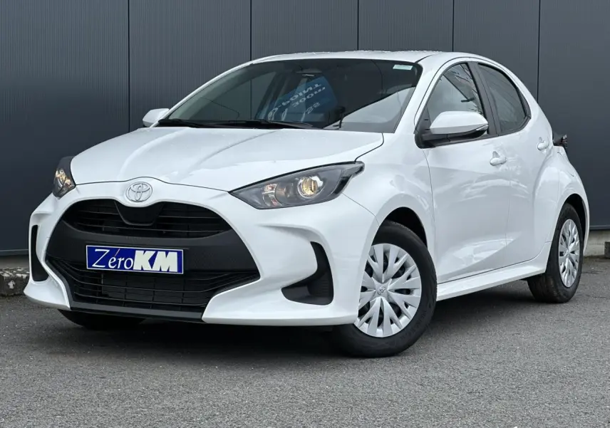 Toyota Yaris hybride blanc pur vue 3/4 avant droit avec calandre noire et jantes tôles à enjoliveurs.