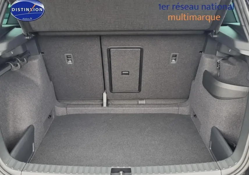 Coffre ouvert du Skoda Karoq noir 2025, montrant la banquette arrière avec trappe à skis et revêtement gris.