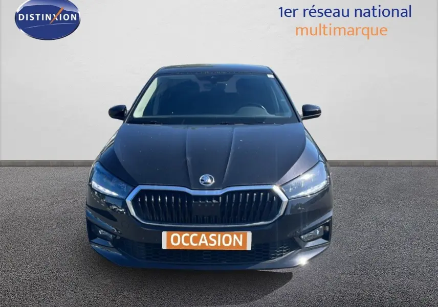 Vue frontale d'une Skoda Fabia noire métal 2025 avec calandre chromée et phares LED allumés.