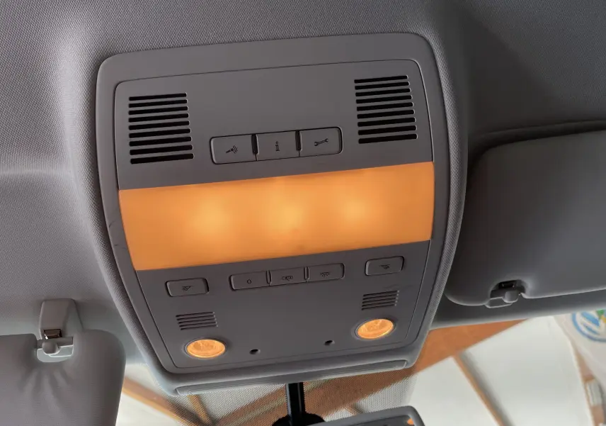 Plafonnier intérieur allumé avec commandes et lampes de lecture dans un Volkswagen Touareg noir 2012.