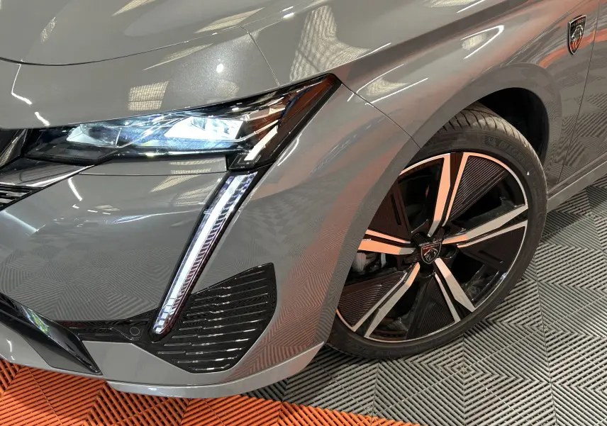 Gros plan sur l'avant droit gris Sellenium du Peugeot 308 SW III GT avec phares LED et jante alliage distinctive.