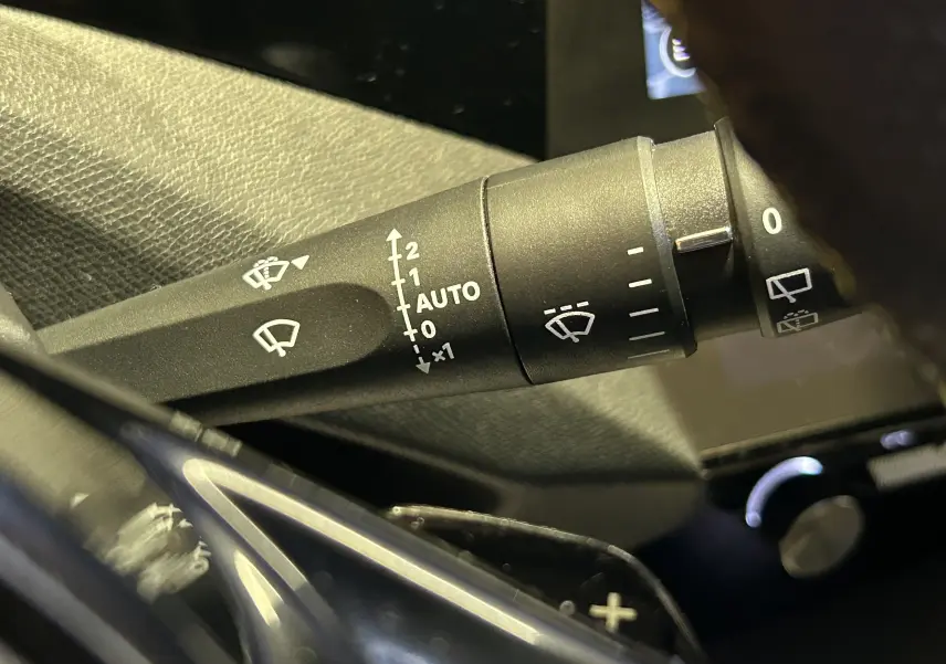 Gros plan sur la commande d'essuie-glace du Peugeot 308 SW 2024, avec réglages automatiques visibles sur le levier noir.