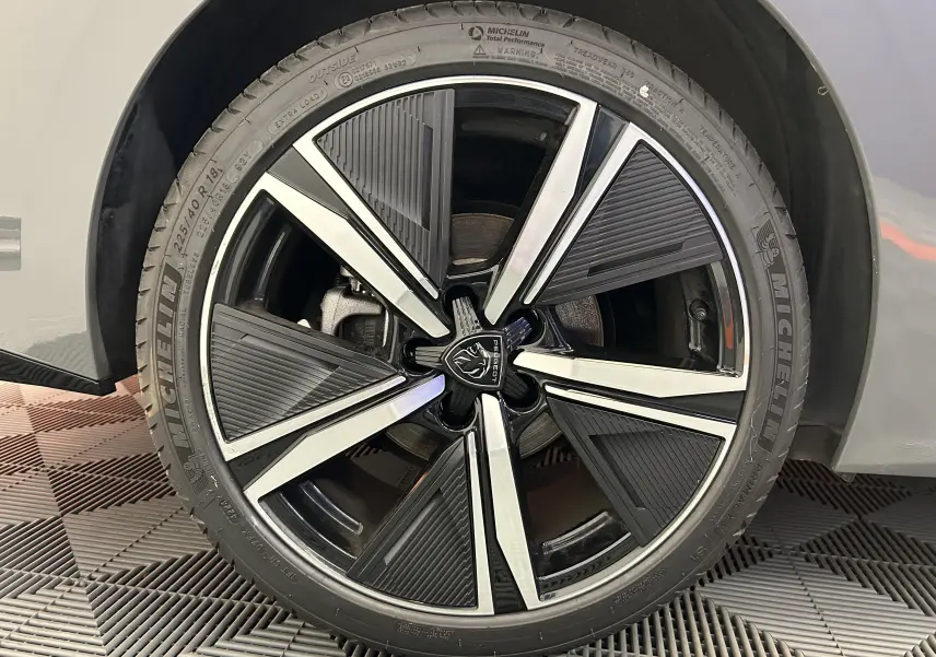 Gros plan sur la roue avant droite de la Peugeot 308 SW III GT gris Sellenium avec jante alliage noire et argentée distinctive.