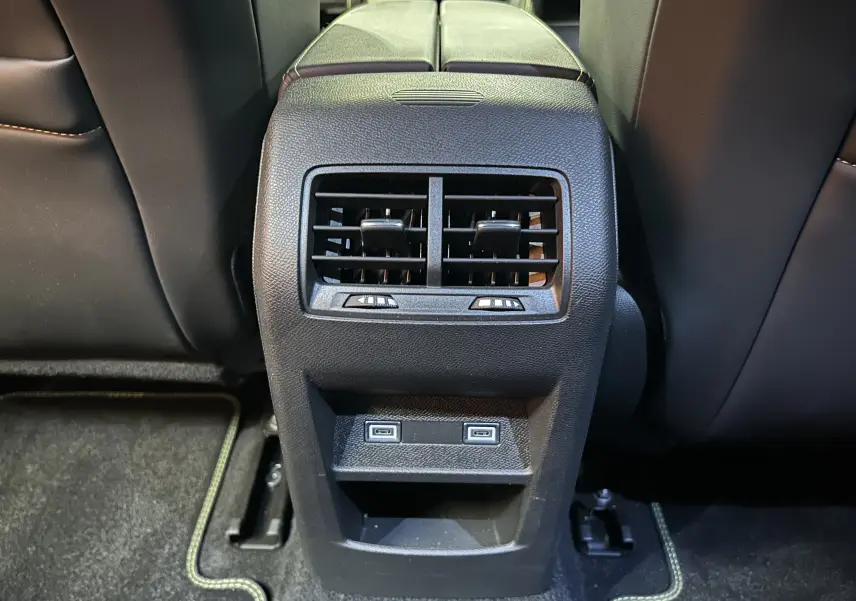 Vue rapprochée de la console centrale arrière noire avec bouches d'aération et deux ports USB sur Peugeot 308 SW gris Sellenium.