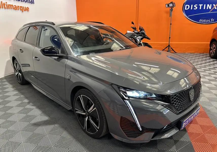 Peugeot 308 SW gris Sellenium vue 3/4 avant droit avec feux LED allumés et jantes alliage noires.