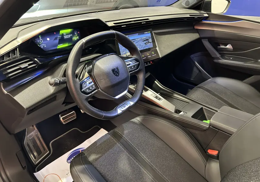 Intérieur moderne de la Peugeot 308 SW 2024, vue côté conducteur, avec volant GT et écran tactile central.