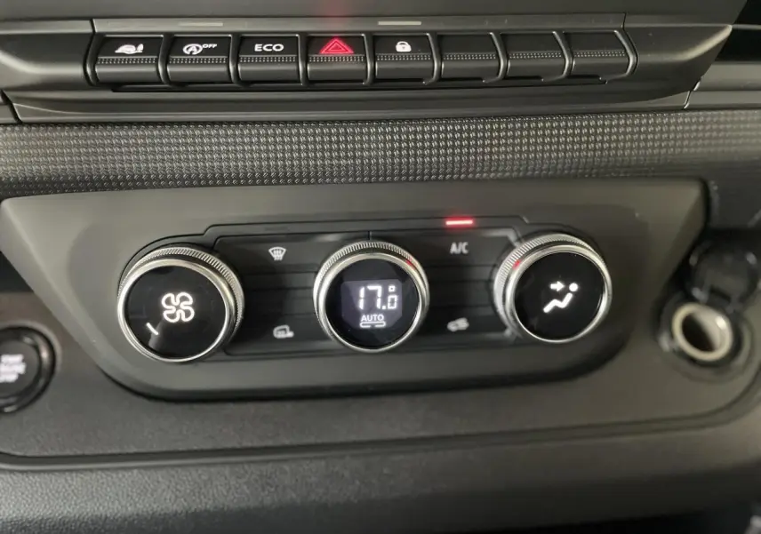 Gros plan sur les commandes de climatisation automatique du Renault Trafic Fourgon gris Comète, affichant 17°C.