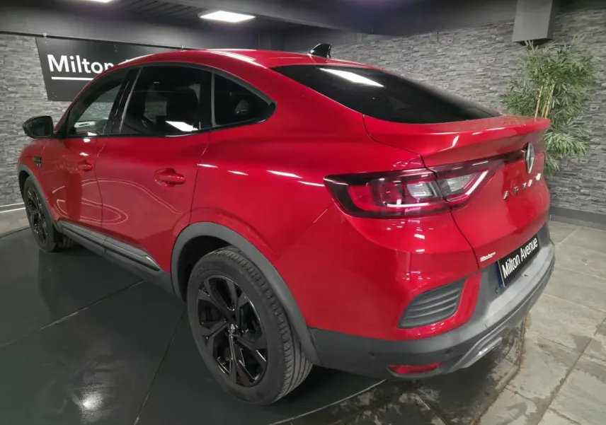 Vue 3/4 arrière droite d'une Renault Arkana Rouge Flamme avec jantes noires et toit ouvrant électrique.