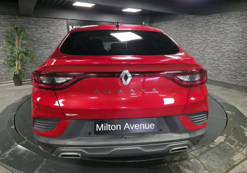 Vue arrière d'une Renault Arkana rouge flamme avec feux reliés et double sortie d'échappement chromée.