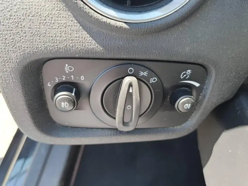 Gros plan sur les commandes d'éclairage noir mat de la Ford Fiesta 2015 Black Edition, avec réglages phares et antibrouillard.