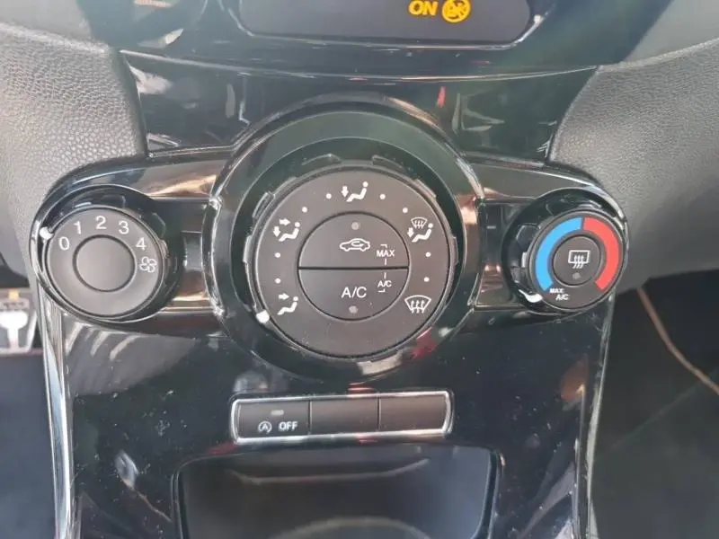Gros plan sur les commandes de climatisation noire de la Ford Fiesta 2015, avec réglages ventilation et chauffage.