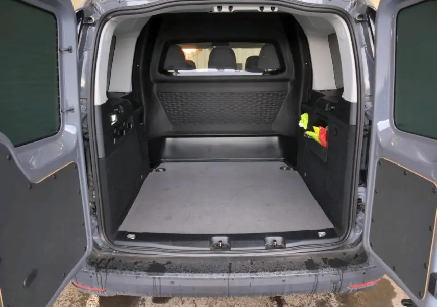 Vue arrière ouverte du Volkswagen Caddy Maxi gris Pure Grey montrant l'espace de chargement vide et les portes battantes.