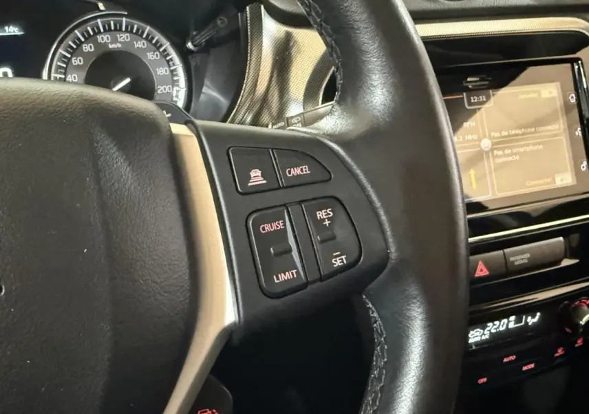 Gros plan sur le volant cuir et alu noir du Suzuki Vitara 2022 avec commandes multifonctions et écran tactile du tableau de bord.