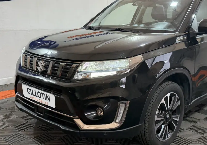 Vue 3/4 avant droite du Suzuki Vitara noir 2022 avec calandre distinctive et jantes alliage bicolores.