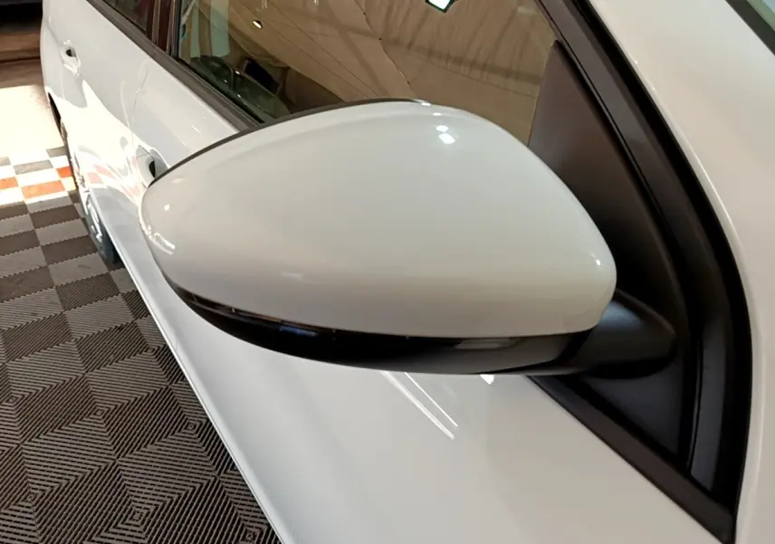 Gros plan sur le rétroviseur droit blanc de la Peugeot 308 2021, avec clignotant intégré et carrosserie visible.
