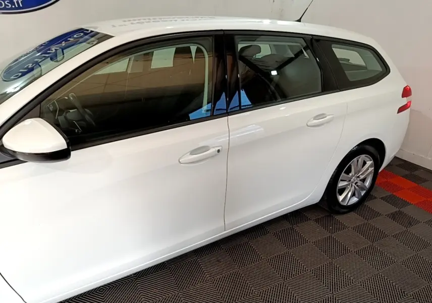 Peugeot 308 break blanc vue de profil côté gauche, avec rétroviseurs électriques et jantes alliage.