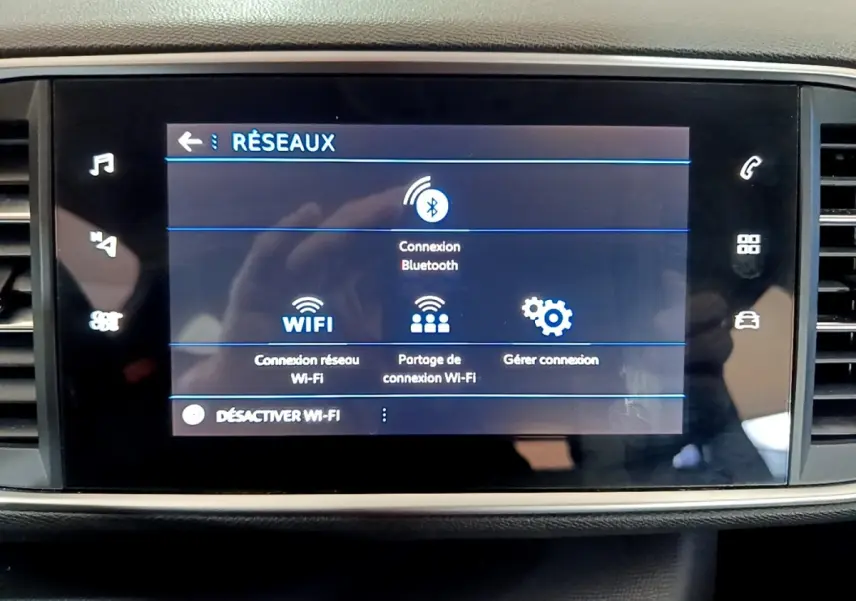 Écran tactile central de la Peugeot 308 blanc montrant le menu de connexion Bluetooth et Wi-Fi.