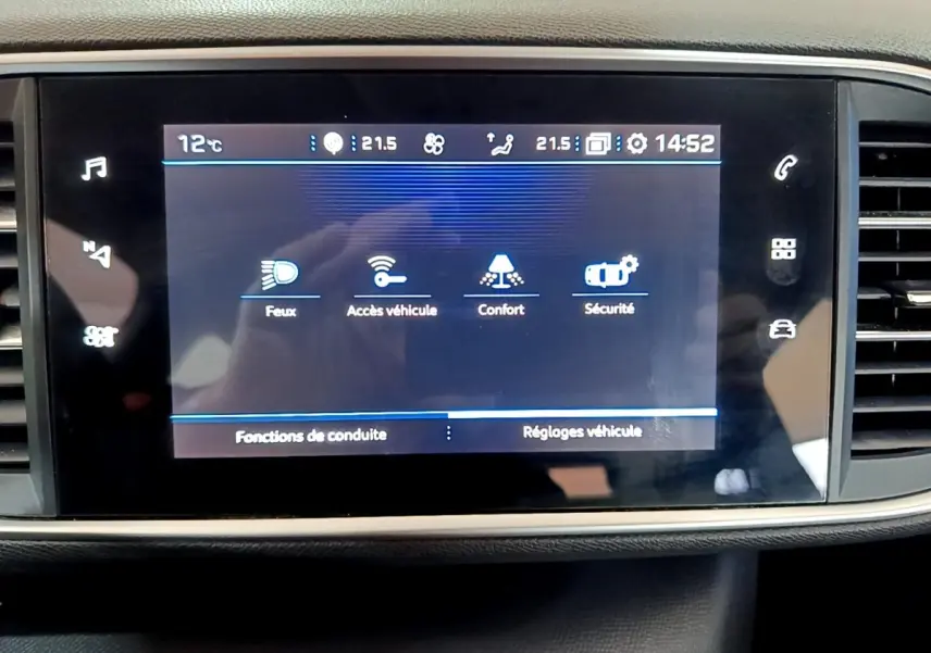 Écran tactile central affichant les réglages du véhicule dans l’habitacle d’une Peugeot 308 blanche de 2021.