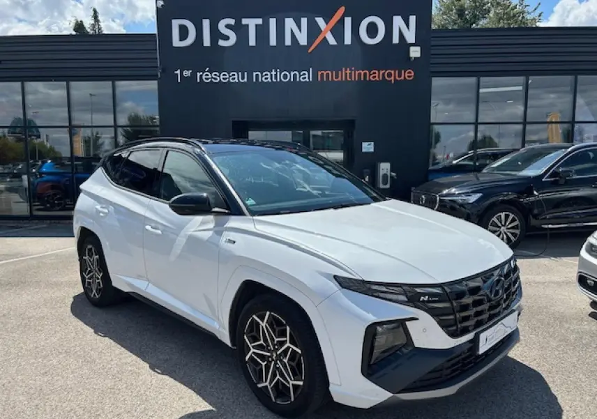 Hyundai Tucson IV blanc polaire toit noir vu en 3/4 avant droit avec calandre N-Line et jantes distinctives.