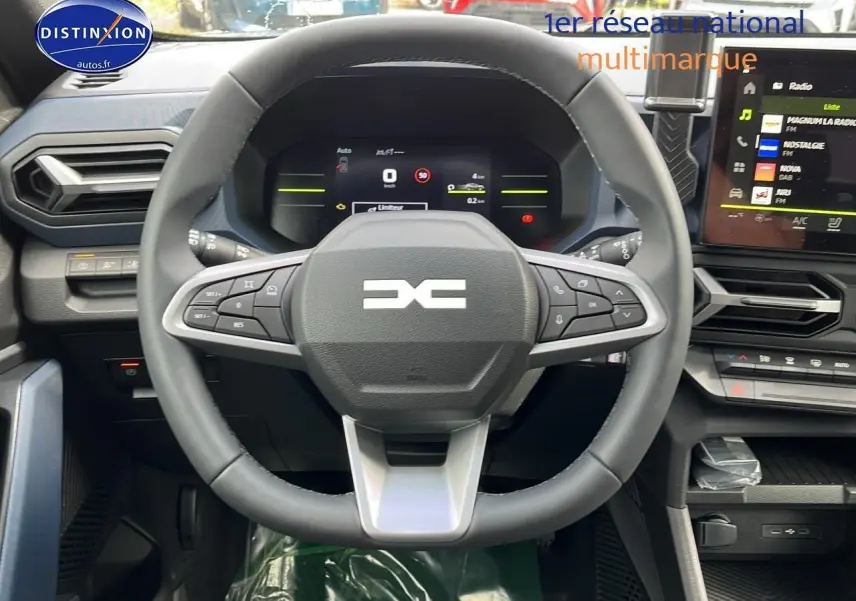 Vue centrée sur le volant multifonction et tableau de bord numérique du Dacia Duster gris schiste 2025.