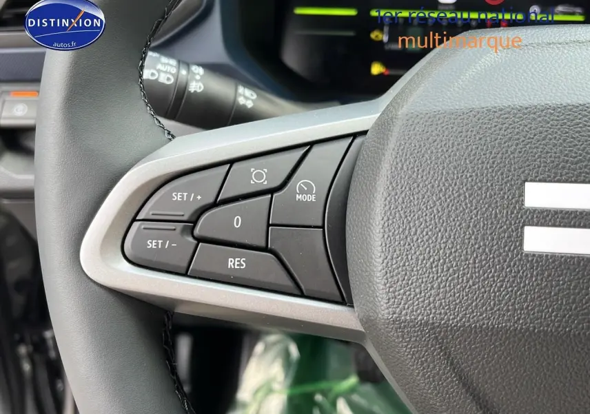 Gros plan sur les commandes de régulateur de vitesse au volant du Dacia Duster 2025 gris schiste.