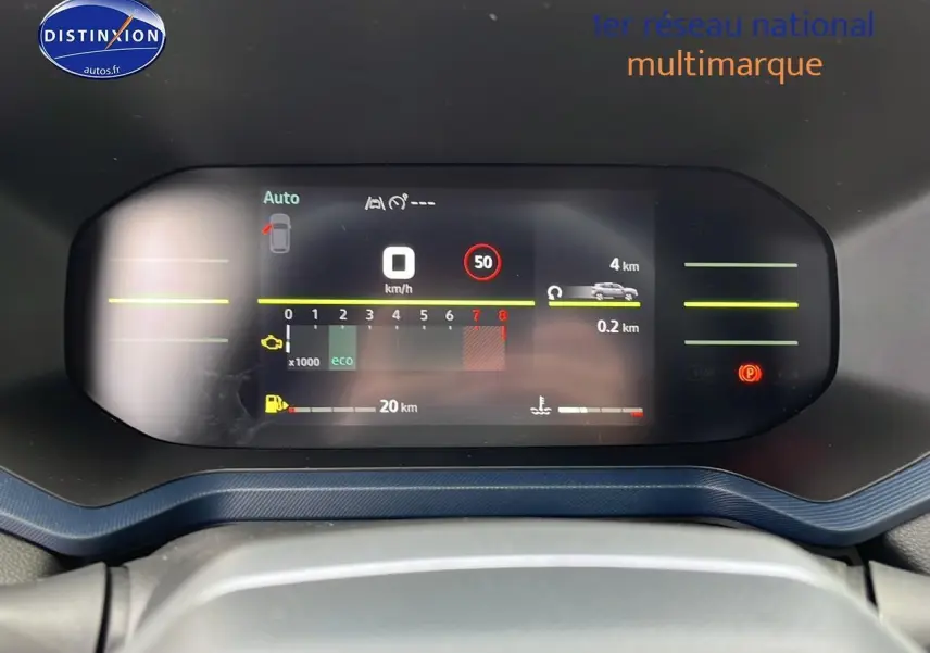 Tableau de bord numérique du Dacia Duster 2025 affichant vitesse, régime moteur et autonomie, vue frontale rapprochée.