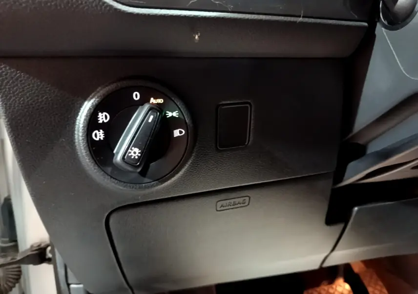 Gros plan sur le bouton de commande des phares dans l’habitacle noir d’un SEAT Ateca gris clair 2022.