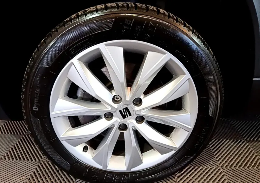 Gros plan sur la jante alliage argentée du SEAT Ateca, mettant en valeur le logo central de la marque.