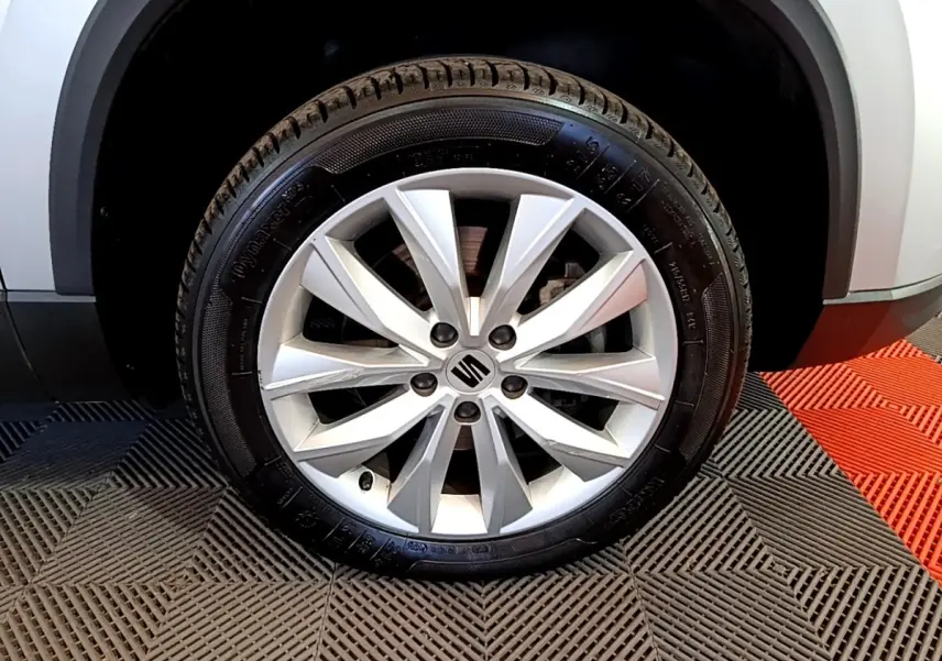 Gros plan sur la roue avant droite avec jante alliage argentée du SEAT Ateca gris clair 2022.