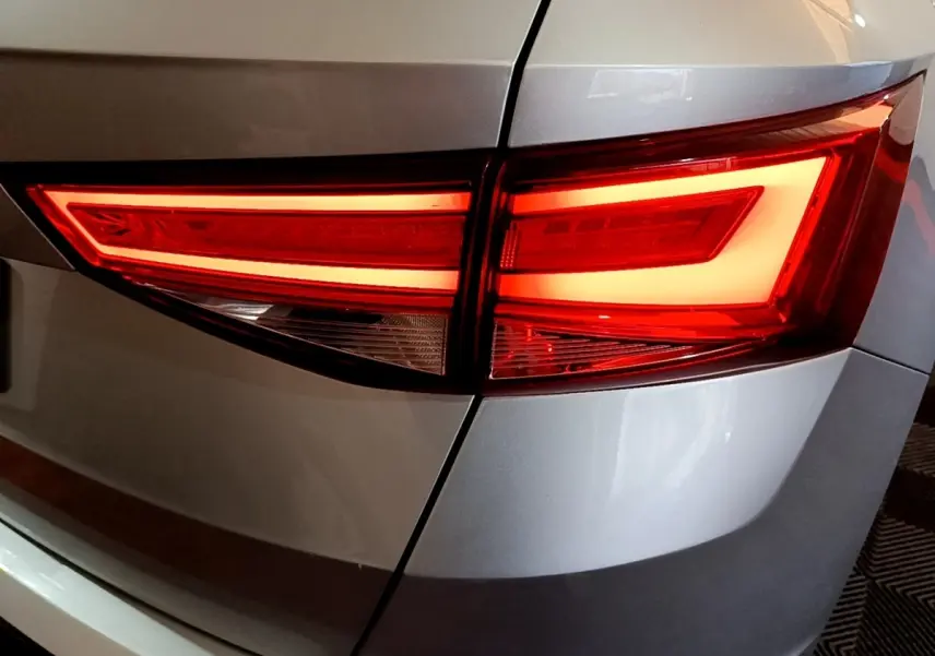 Gros plan sur le feu arrière droit rouge allumé d’un SEAT Ateca gris clair, version 2022.