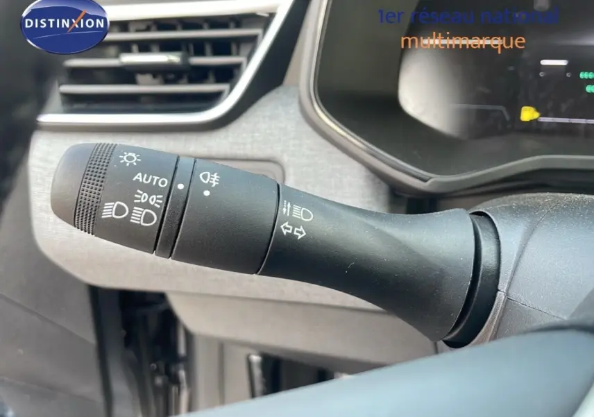 Gros plan sur la commande des phares et clignotants à gauche du volant d’une Renault Clio Evolution Blue dCi 100 2025.