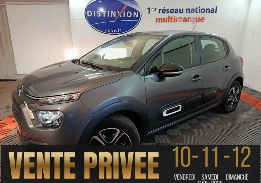 Citroën C3 BlueHDi 100 gris foncé vue 3/4 avant droit, avec protections latérales noires et jantes stylisées.