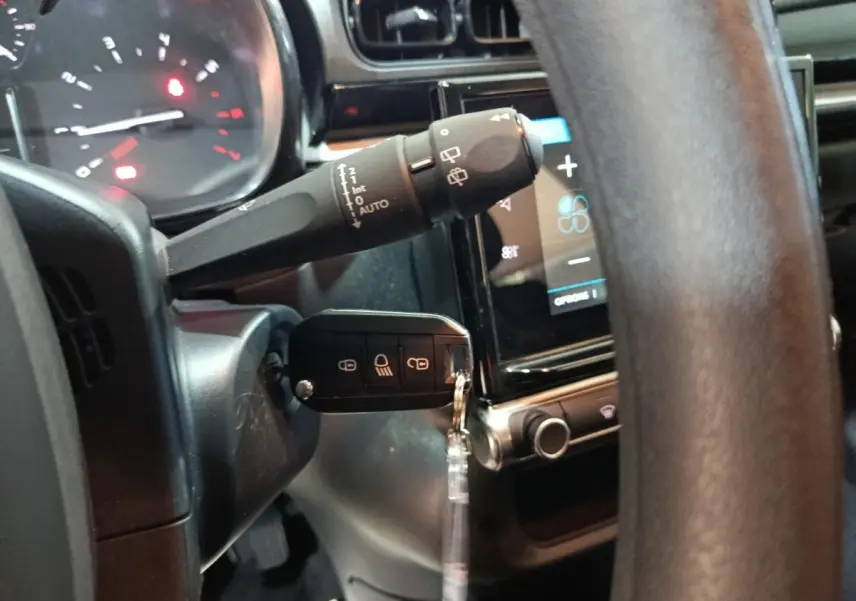 Vue intérieure rapprochée du volant et du tableau de bord tactile de la Citroën C3 gris foncé 2024.
