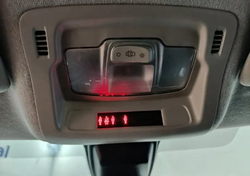 Gros plan sur le plafonnier intérieur gris avec éclairage rouge des ceintures de sécurité dans une Citroën C3 2024.