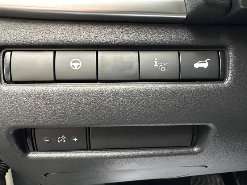 Gros plan sur les boutons de commande intérieurs du Nissan Qashqai Hybrid e-POWER 2025, finition N-Connecta, tableau de bord noir.