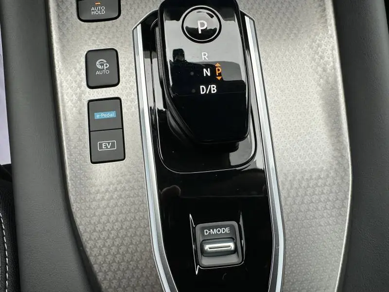 Gros plan sur la console centrale du Nissan Qashqai Hybrid e-POWER 2025 avec levier de vitesse automatique et boutons de mode de conduite.
