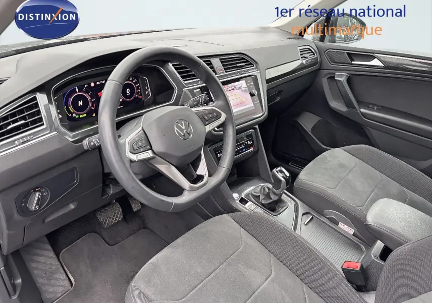 Intérieur du Volkswagen Tiguan 1.4 E-Hybrid 2022, vue côté conducteur montrant le tableau de bord et la console centrale grise.