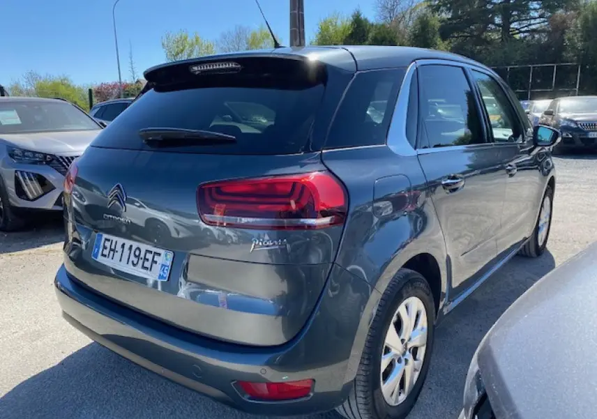 Vue 3/4 arrière droite d'une Citroën C4 Picasso gris shark avec feux arrière LED et jantes alliage 16 pouces.