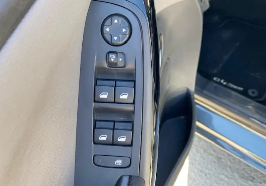 Gros plan sur les commandes de lève-vitres et rétroviseurs côté gauche d'une Citroën C4 Picasso gris Shark 2016.
