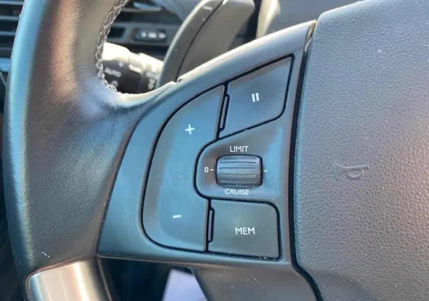 Gros plan sur les commandes de régulateur de vitesse au volant cuir d'une Citroën C4 Picasso gris Shark de 2016